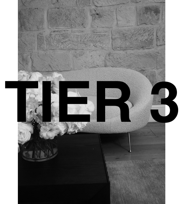 Tier 3 skin subscription at Ashleigh Hasson, a non-surgical skin aesthetics studio in Darling Point, Sydney—featuring a black and white bouclé couch, a coffee table with fresh flowers, and elegant sandstone walls.